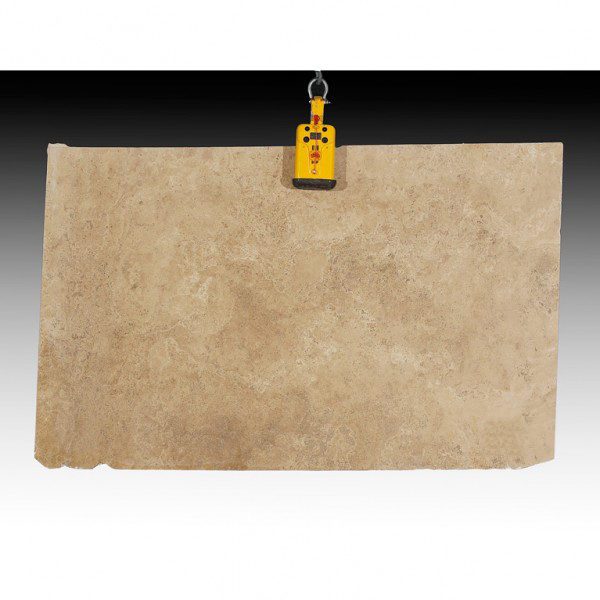 A large piece of Noce Travertine Slab hanging from a hook.
