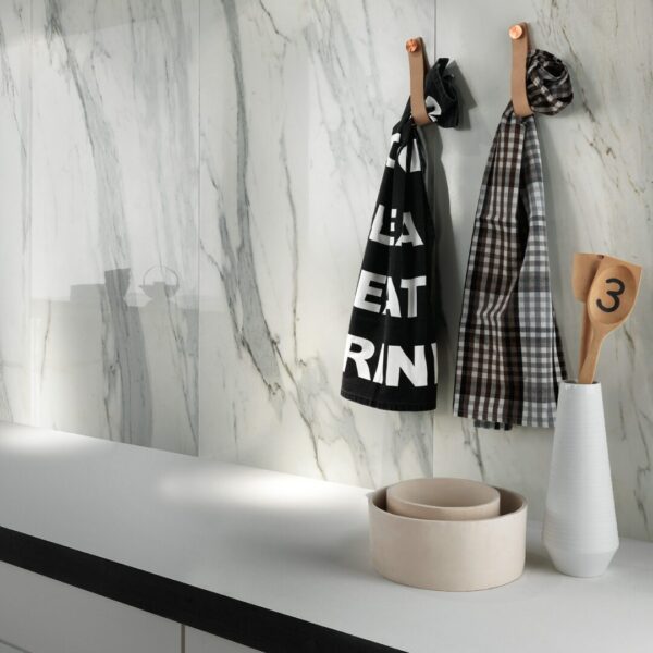 A white counter top with some black and white towels hanging on it