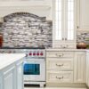 A kitchen with white cabinets and tiled backsplash.