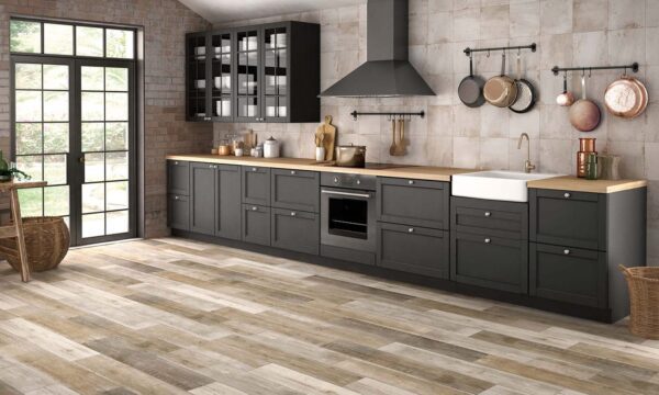 A kitchen with wooden floors and black cabinets.