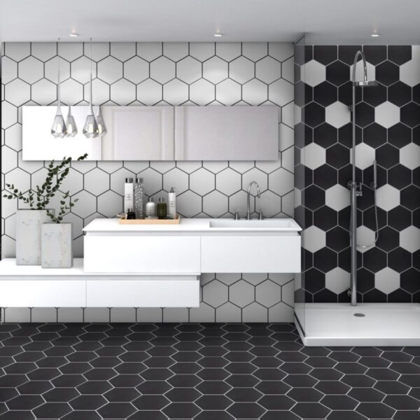 A bathroom with black and white tiles, a shower and a sink.