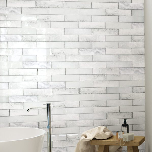 A white brick wall with a tub and sink in it