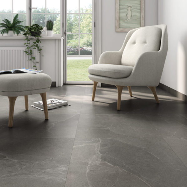 A living room with a grey tile floor and a chair.